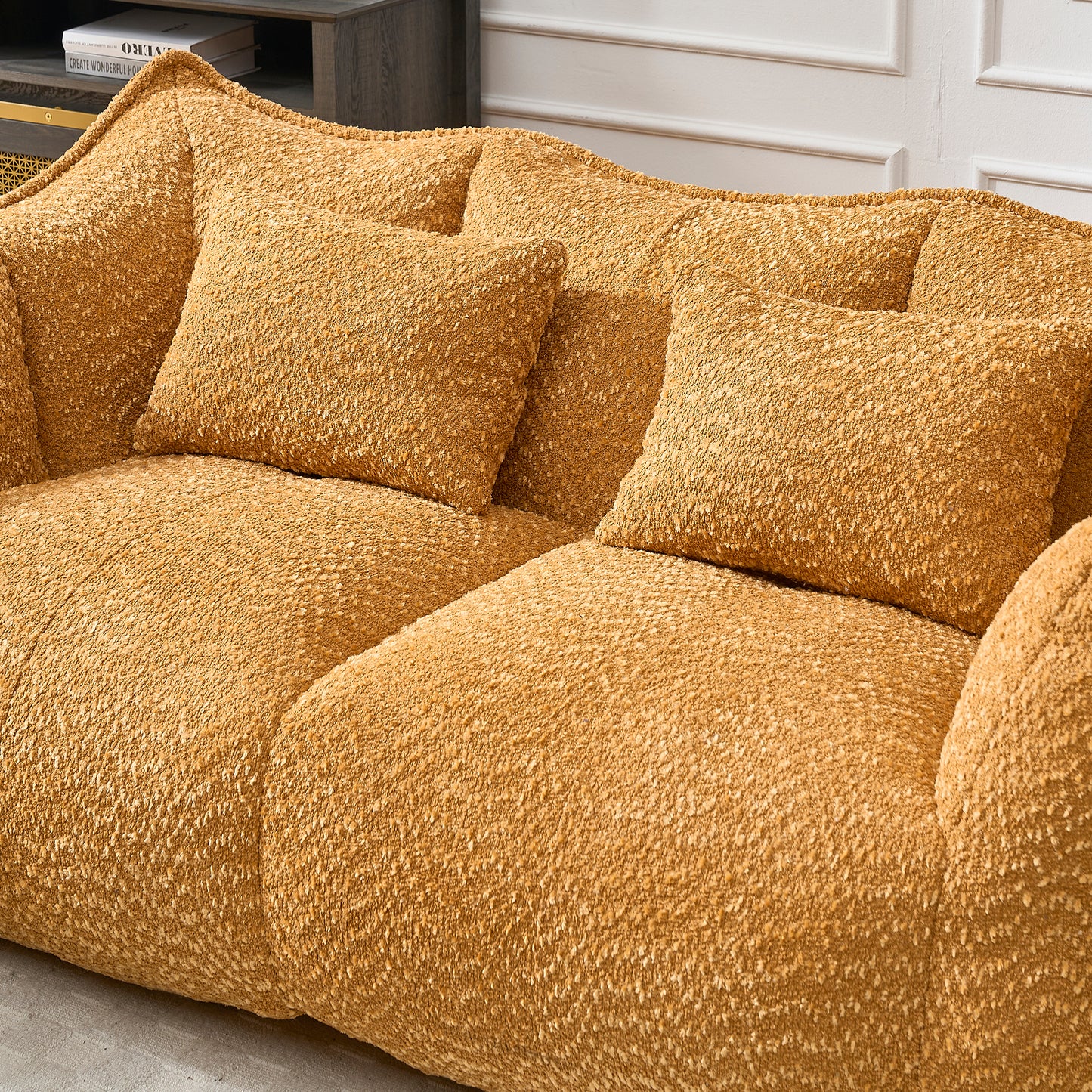 Textured ochre boucl sofa with two matching accent pillows for a cozy living room