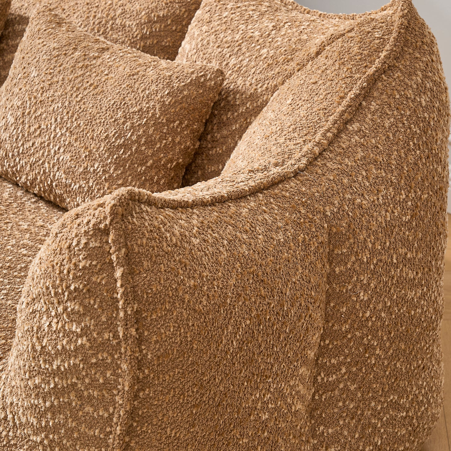 Closeup of a textured brown boucle fabric sofa with plush cushions perfect for cozy living rooms
