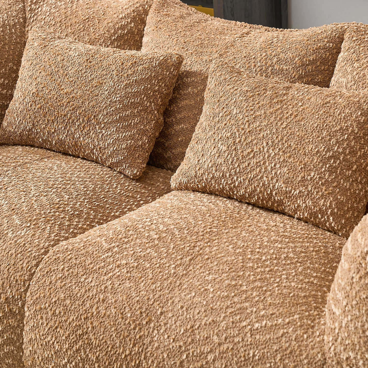 Closeup of a plush textured brown boucle fabric on a sectional sofa