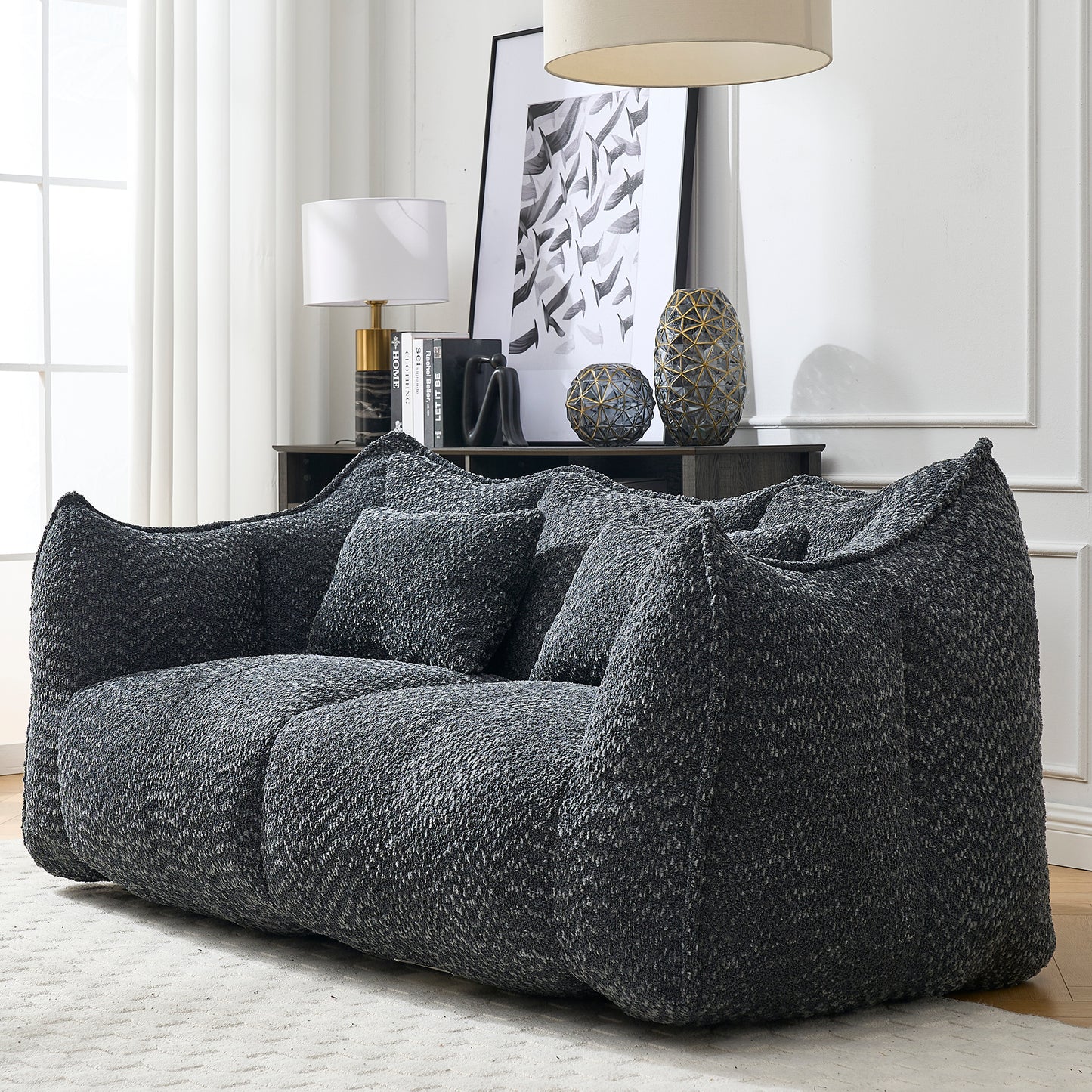 Plush charcoal grey boucl sofa with deep seating and matching throw pillows