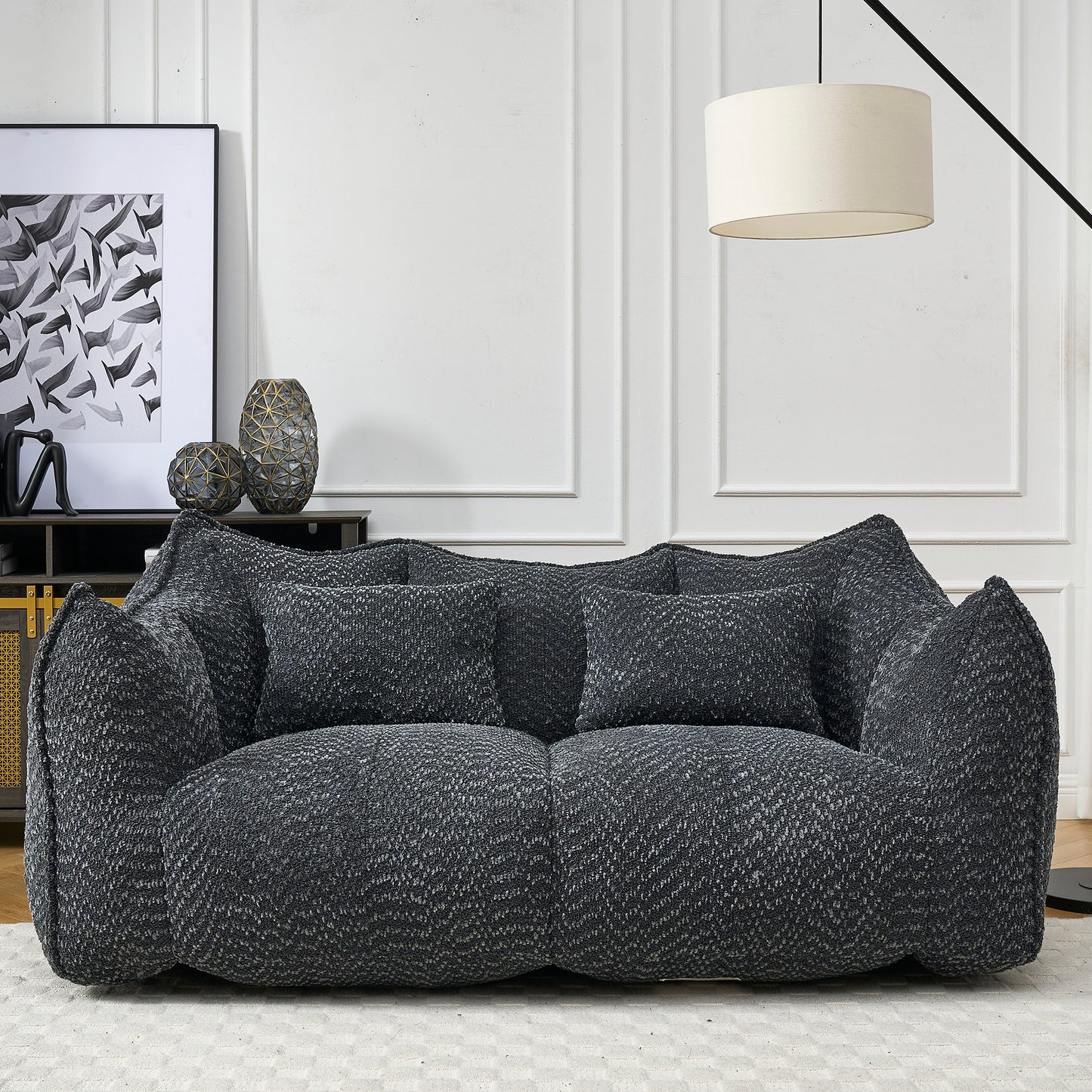 Plush dark gray boucl sofa with plush throw pillows perfect for a cozy living room