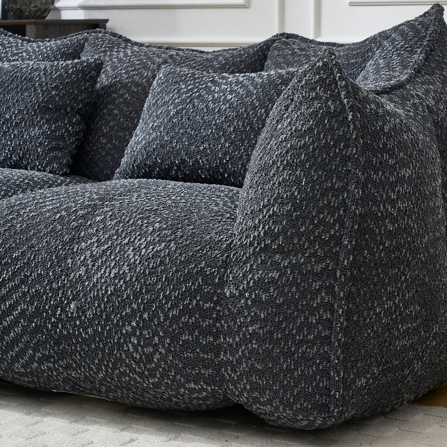 Textured charcoal grey bean bag sofa with plush cushions