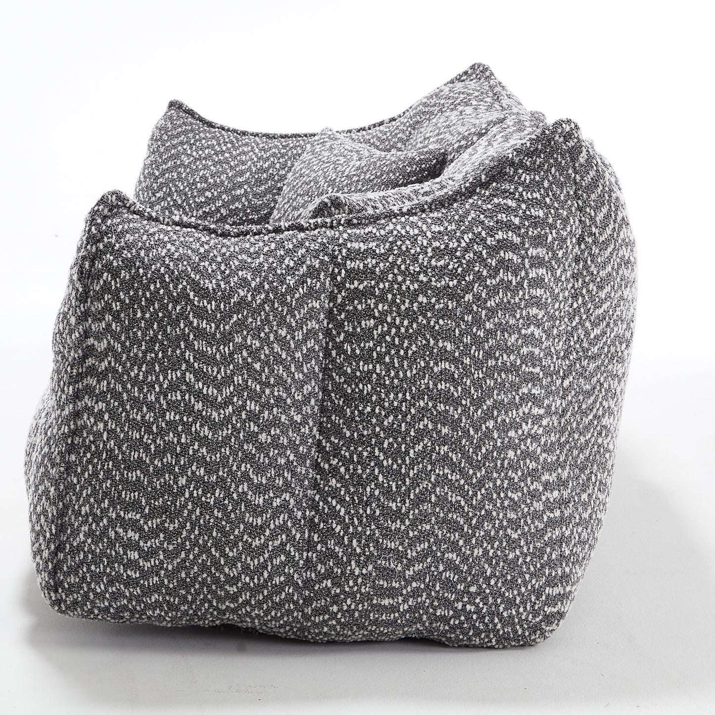 Chunky knit floor pouf in charcoal gray with white flecks providing cozy seating