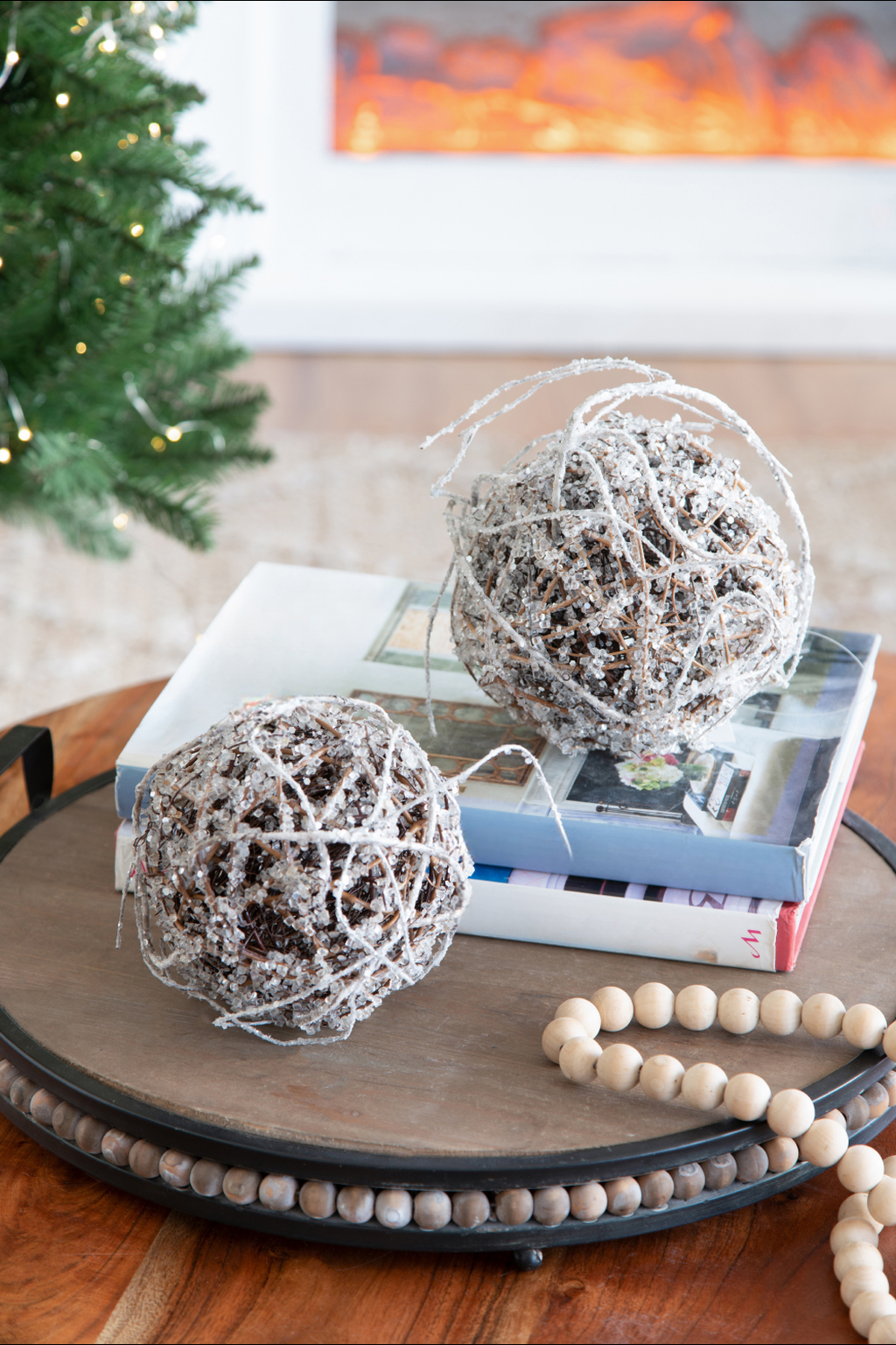Two decorative orbs with sparkly white twine and crystal embellishments rest on books