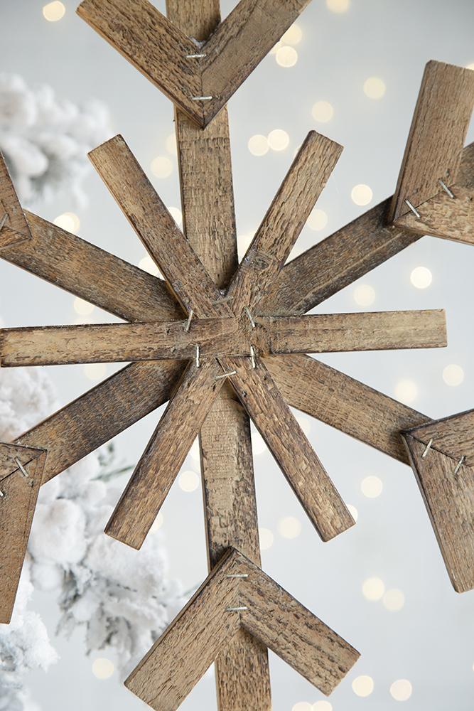 Rustic wooden snowflake Christmas ornament with weathered texture perfect for tree decor