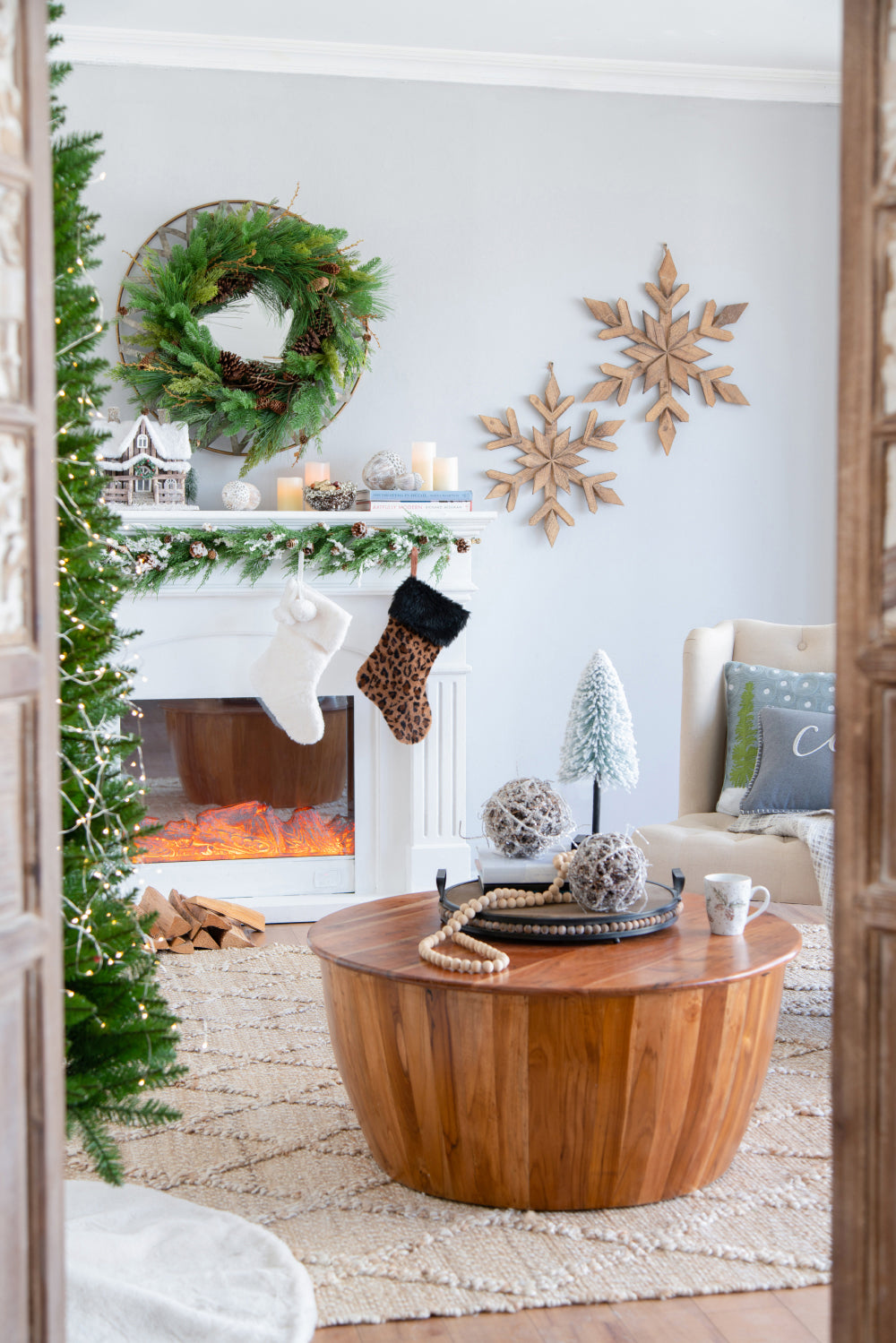 Fluffy white Christmas stocking with pompom detail hanging on fireplace mantel