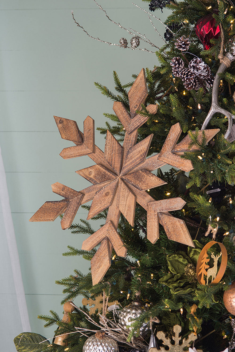 Rustic wooden snowflake ornament on a decorated Christmas tree