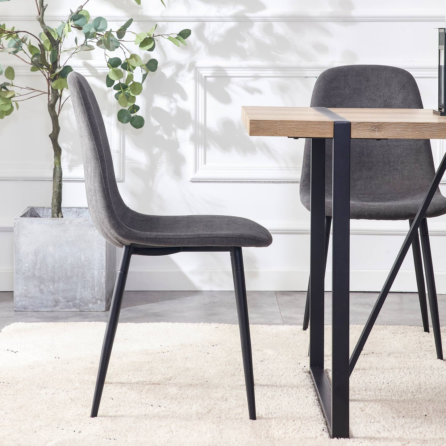 Grey upholstered dining chair with slim black metal legs