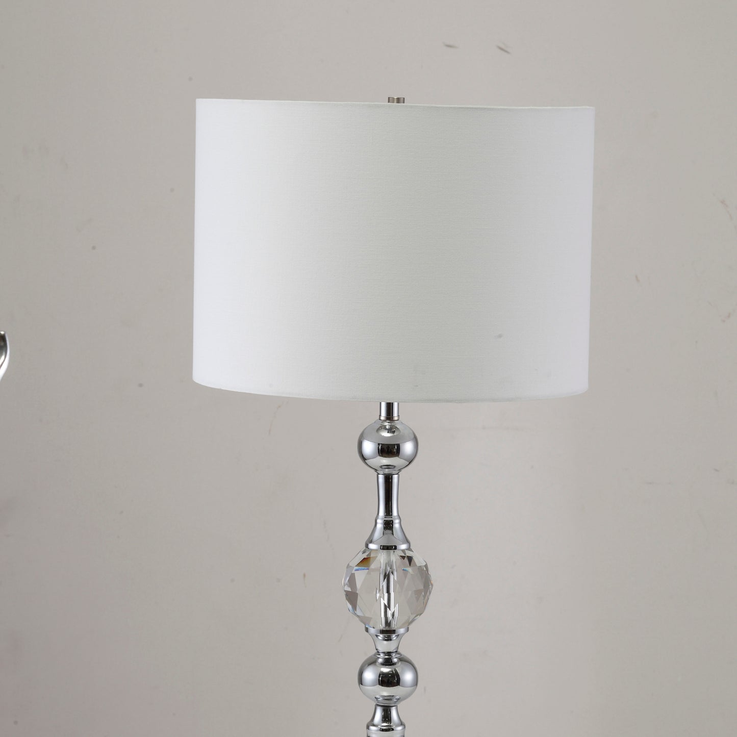 Polished chrome table lamp with a crystal accent and white fabric shade