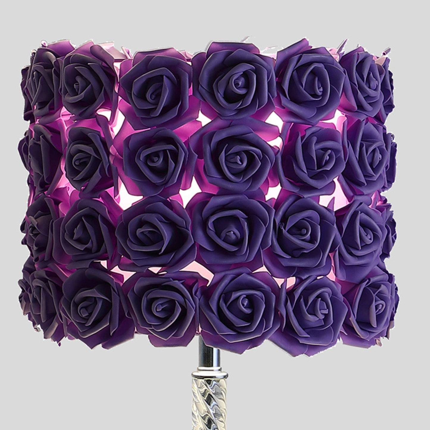 Purple rose lampshade with intricate floral design casting a soft glow