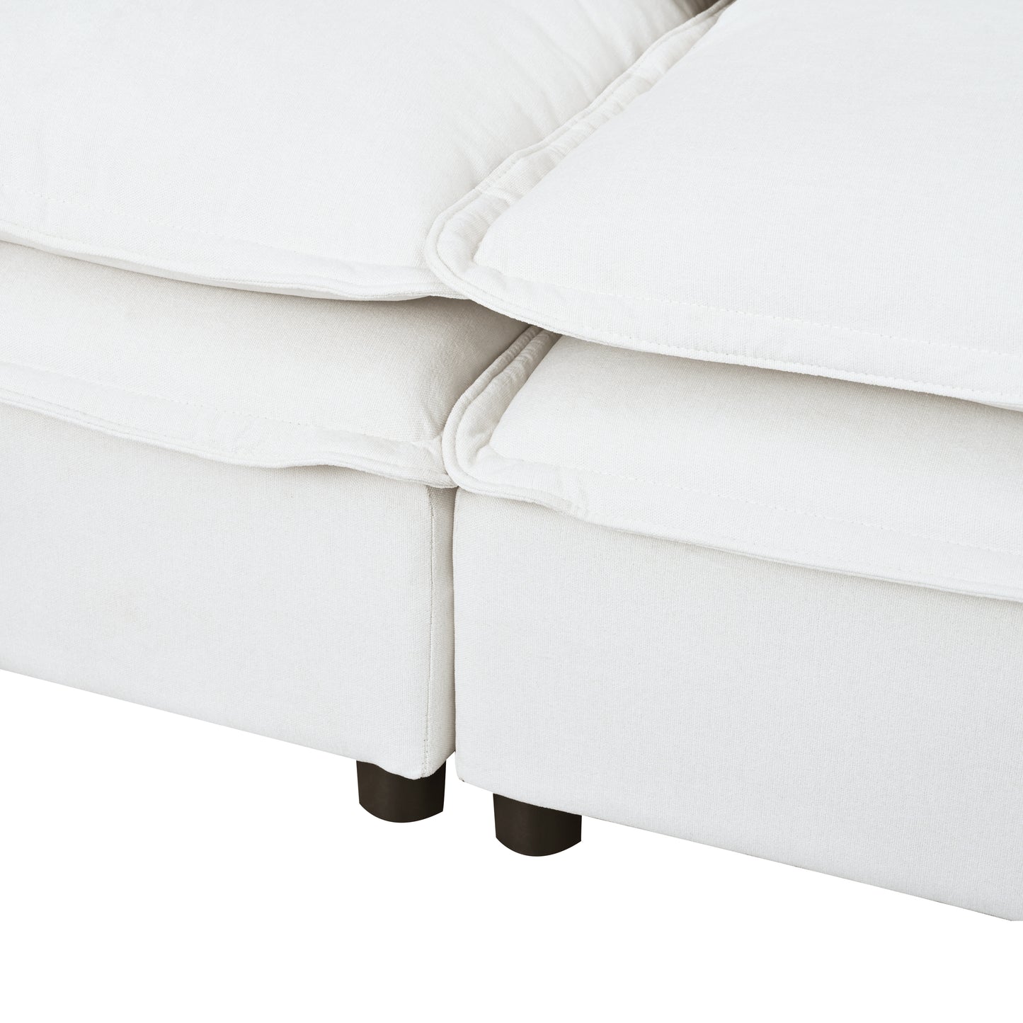 Closeup of a plush white linen sofa section with dark wooden legs