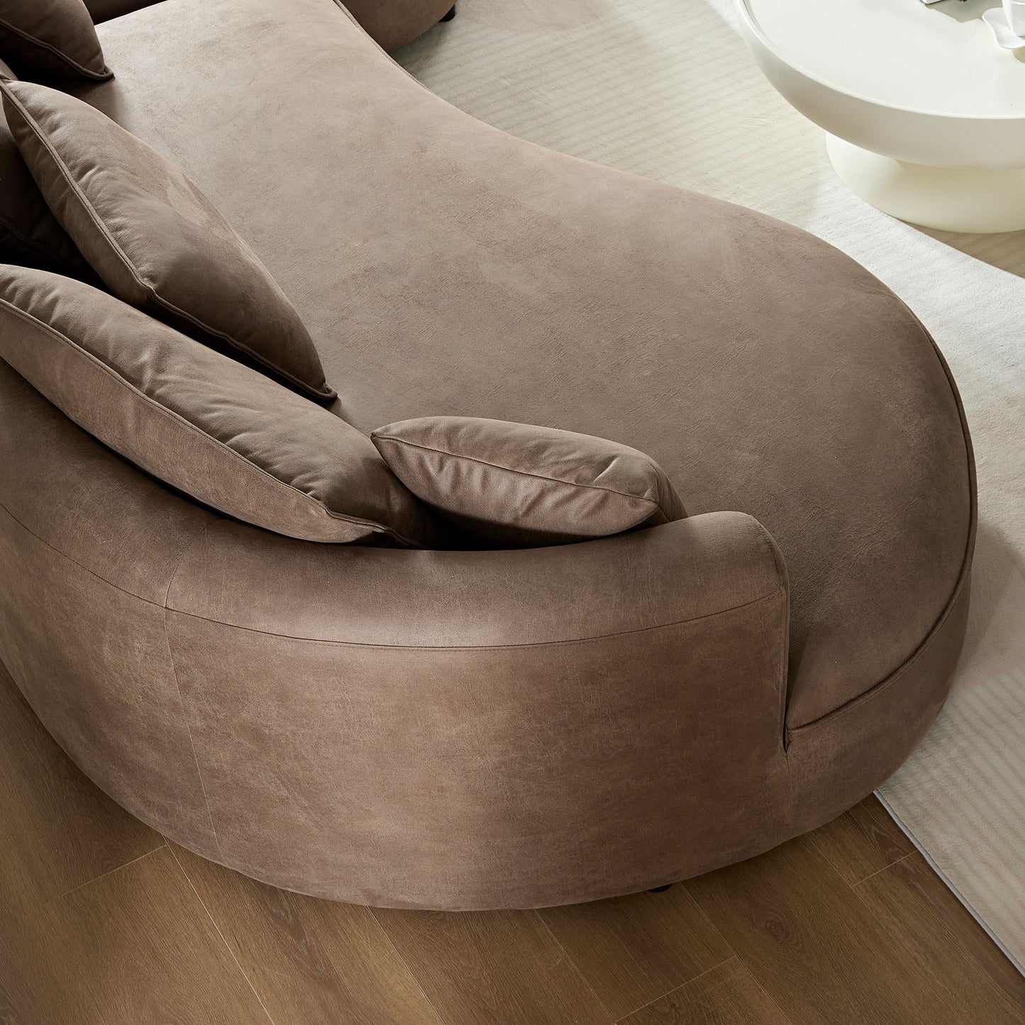 Curved taupe suede sectional sofa with plush cushions perfect for modern living rooms