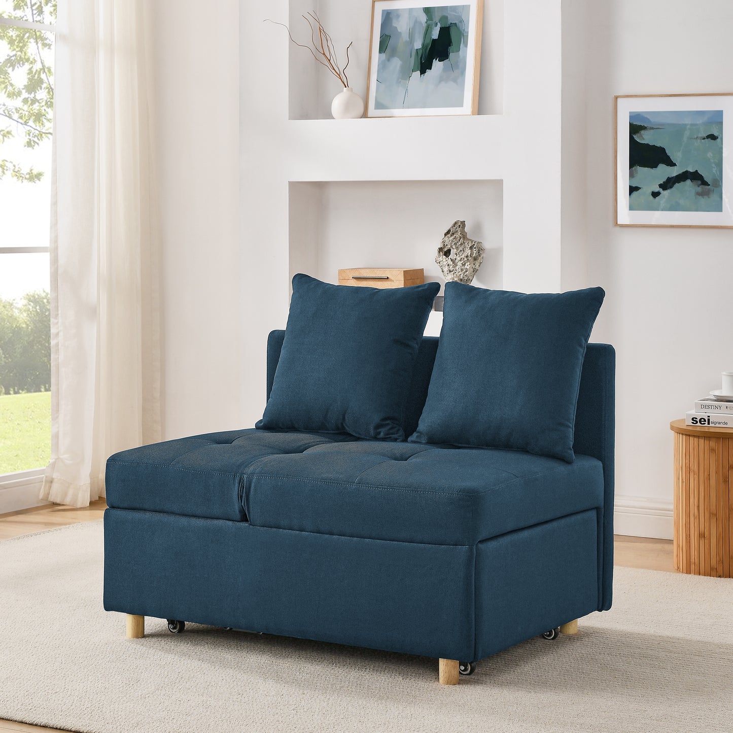 Dark blue upholstered convertible chair with tufted seat and matching pillows