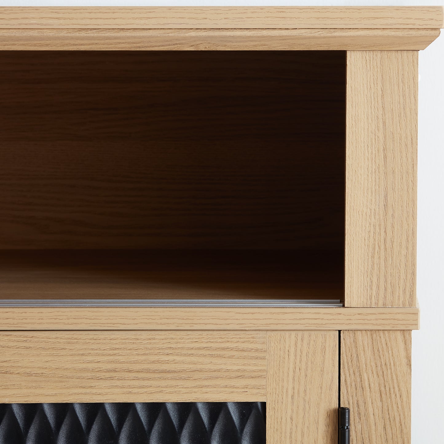 Closeup of light oak wood veneer cabinet panel with textured black insert