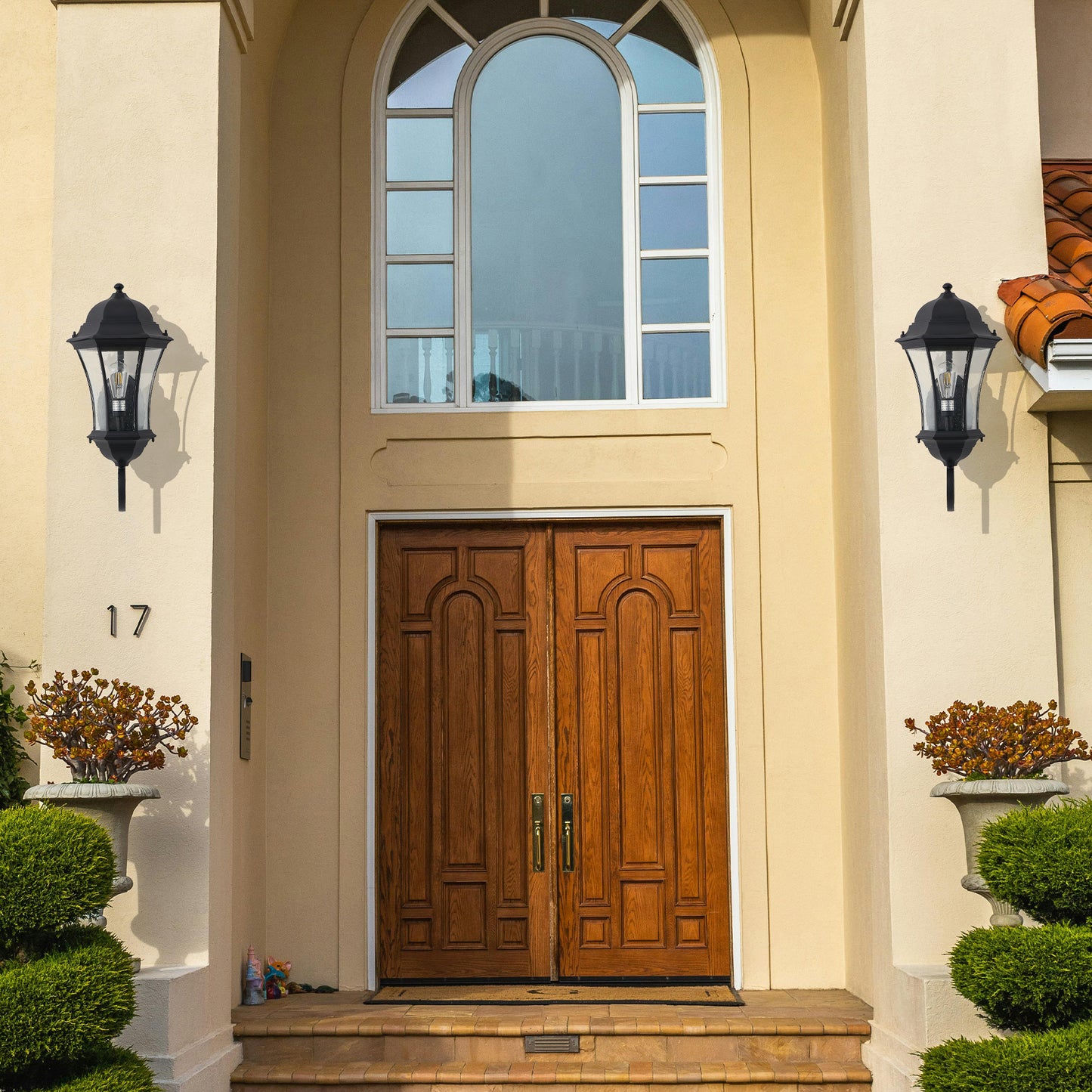 Classic black outdoor wall lantern with clear glass panels providing elegant entryway lighting