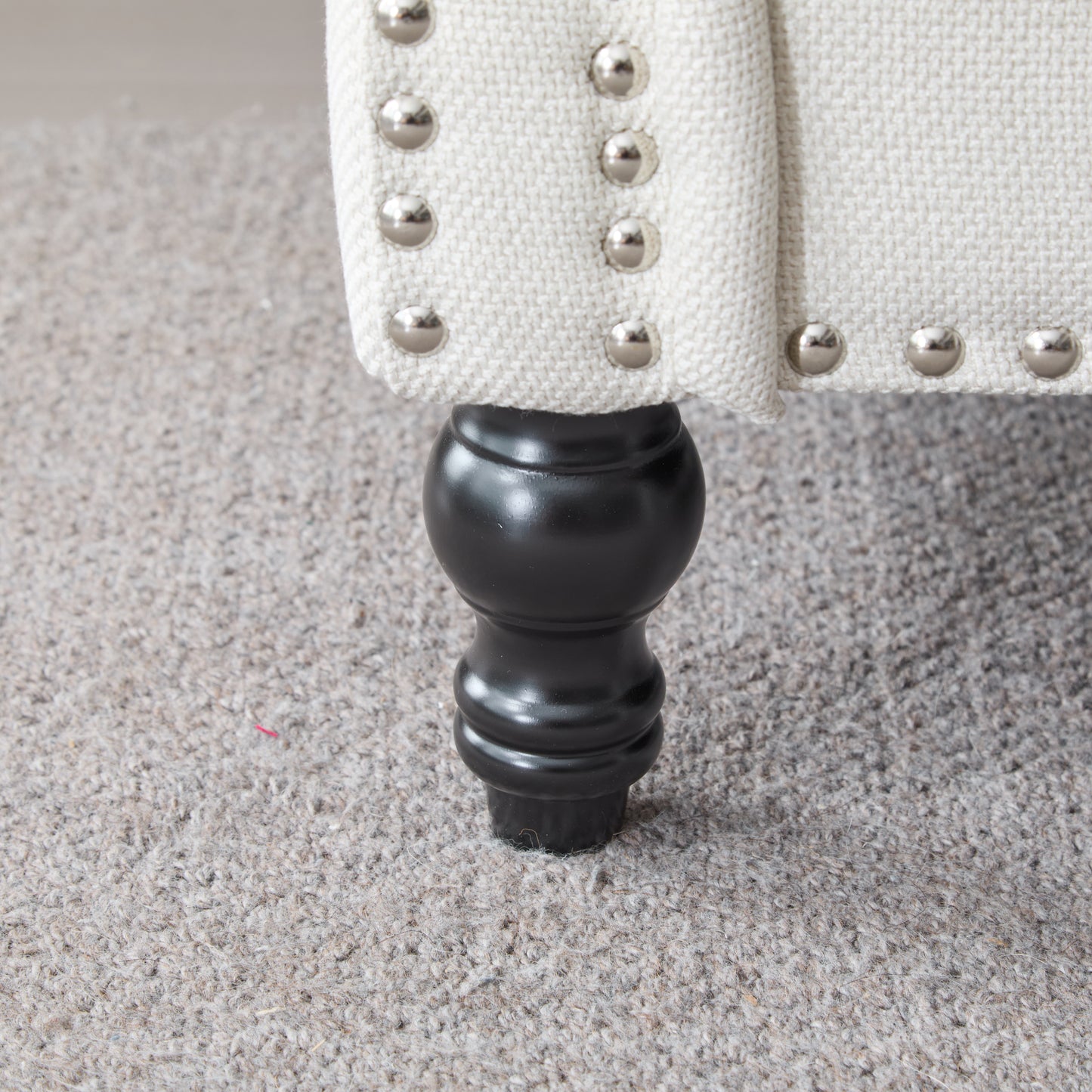 Cream linen accent chair with silver nailhead trim and black turned leg