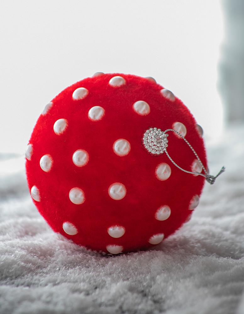 Red polka dot Christmas ornament with flocked texture and silver loop