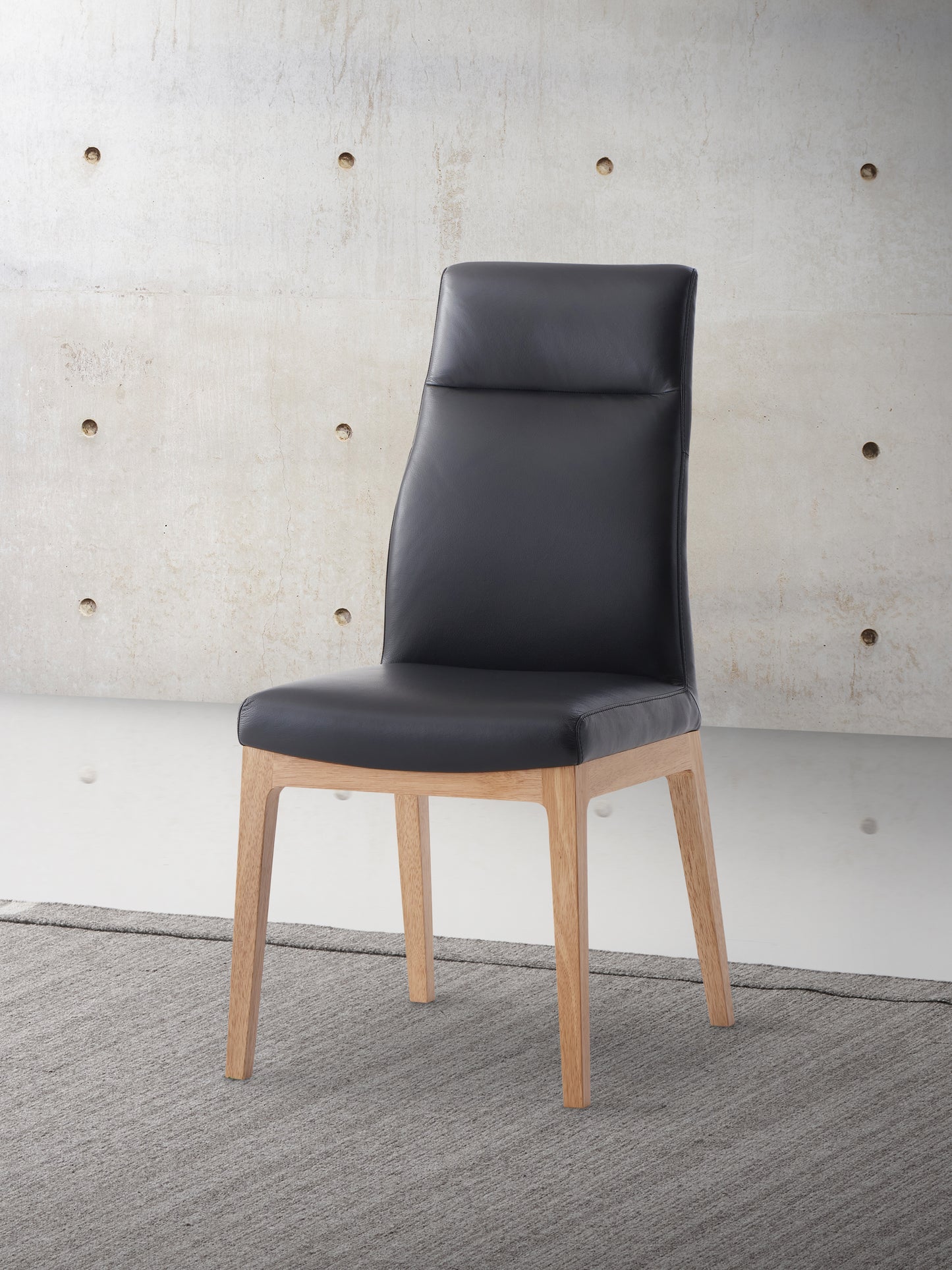 Black leather dining chair with light wood legs