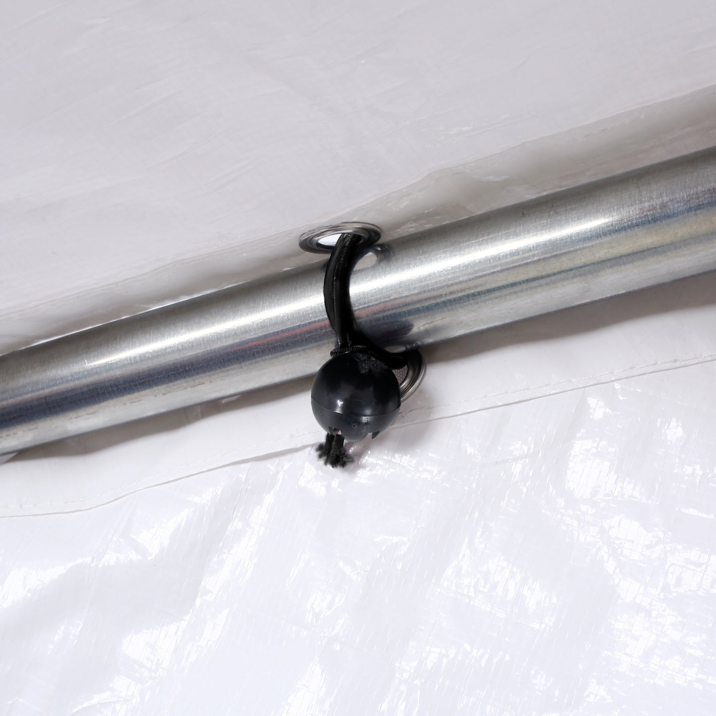 White tarp grommet with bungee cord and ball for secure attachment