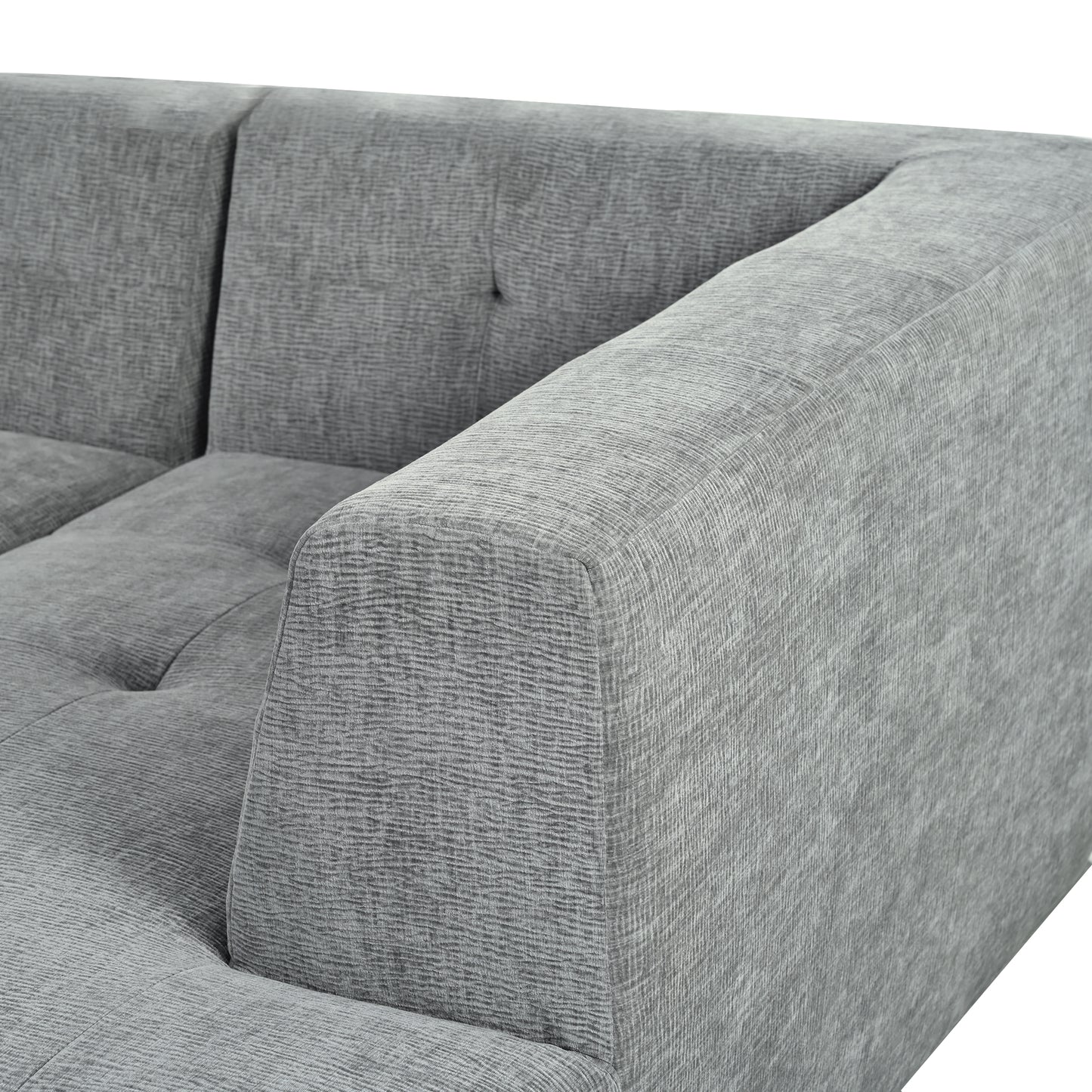 Closeup of a grey textured fabric sofa armrest and tufted seat cushion