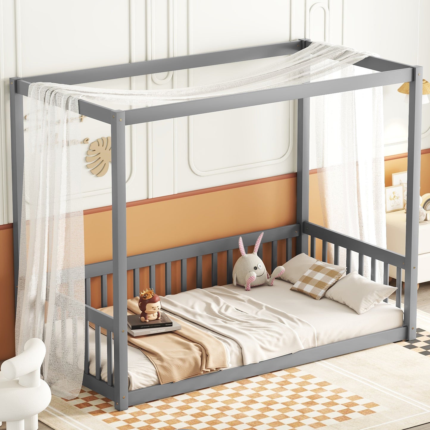 Grey wooden canopy bed with sheer white drapes and plush toys