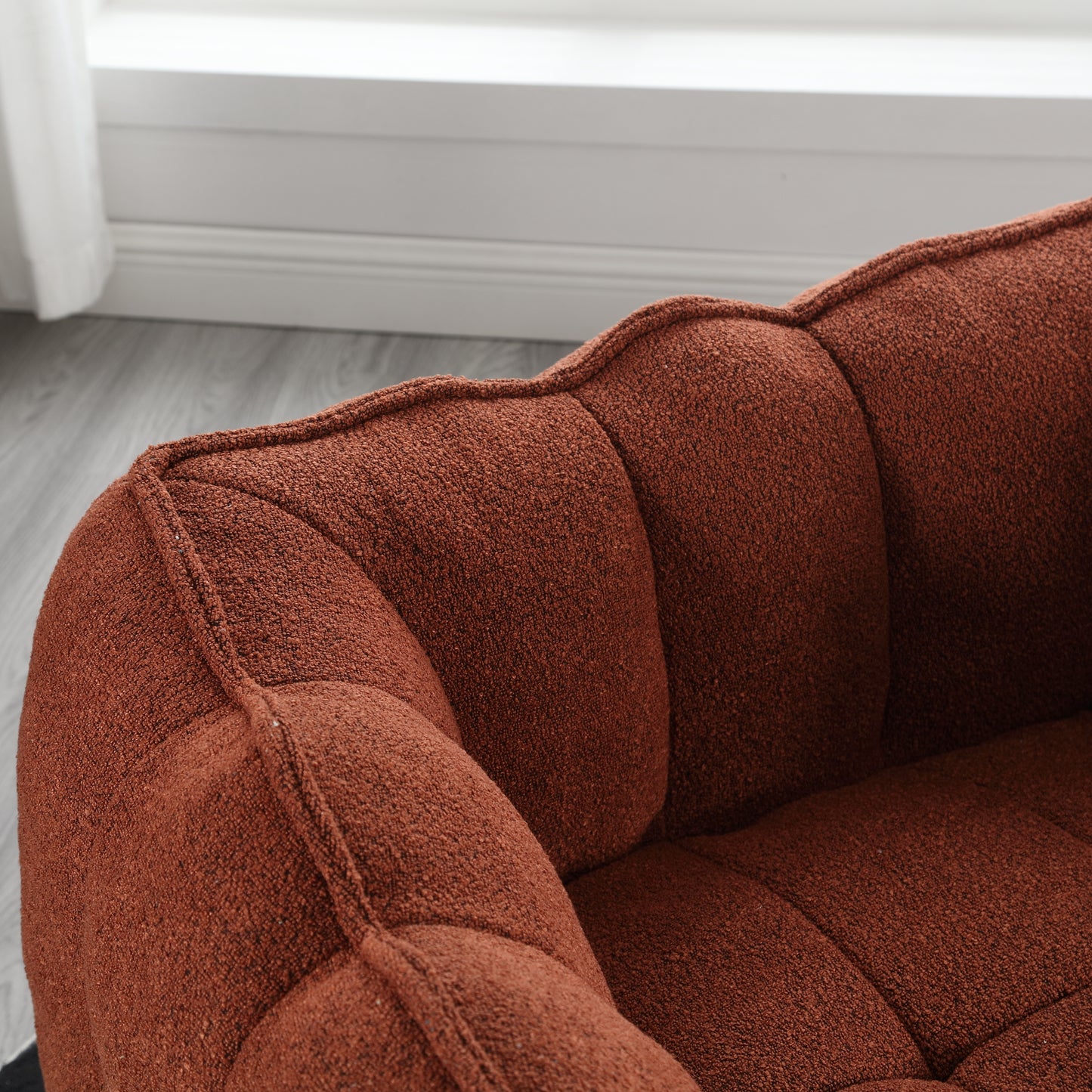 Tufted terracotta boucle accent chair with plush cushioning for comfortable seating