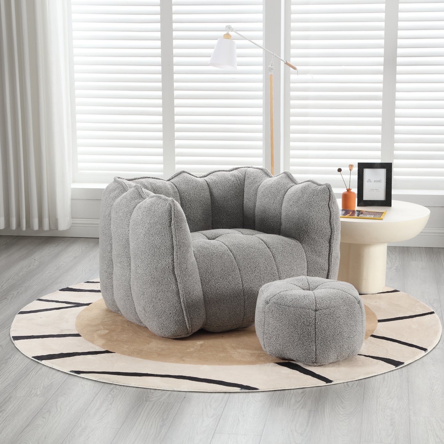 Plush grey accent chair with rounded arms and a matching ottoman modern design