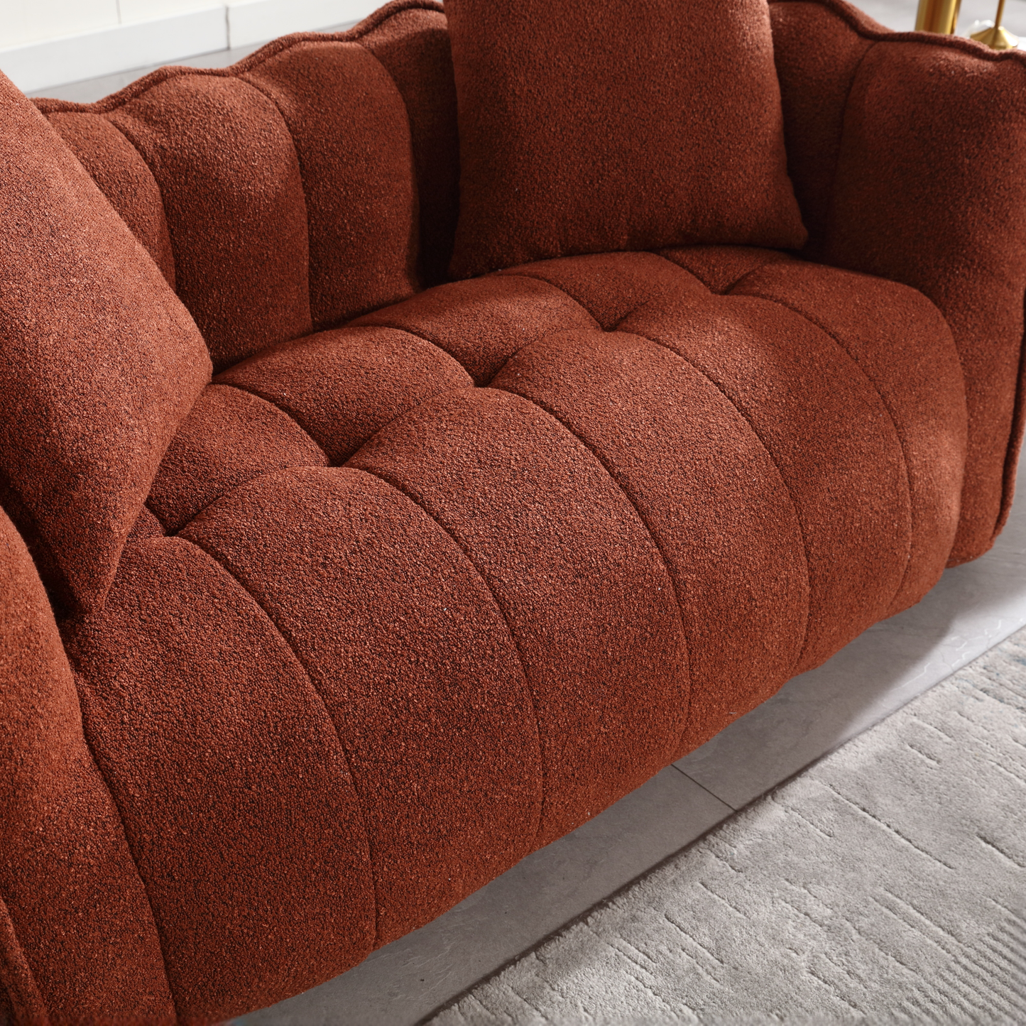 Plush rust boucle sofa with deep tufted cushions and coordinating pillows perfect for a cozy living room