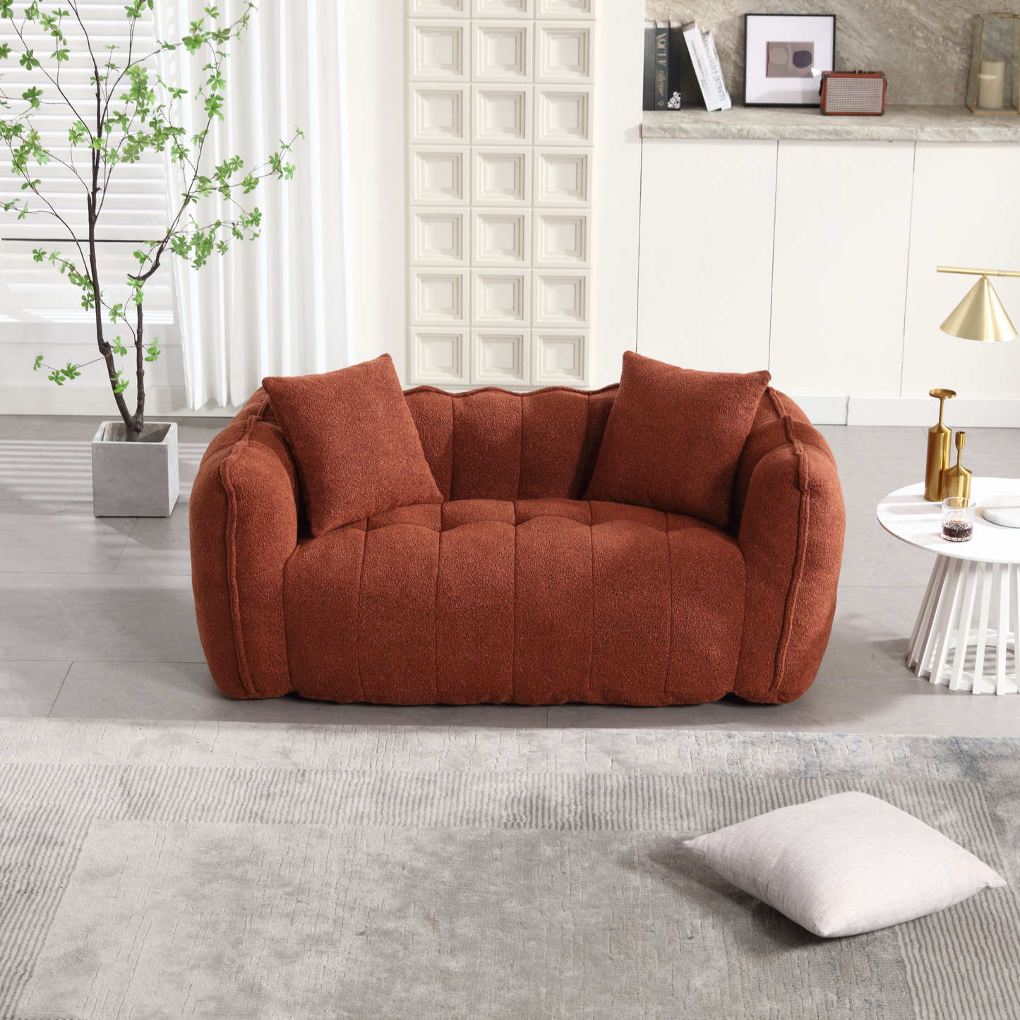 Plush orange boucle fabric love seat with button tufting and two throw pillows