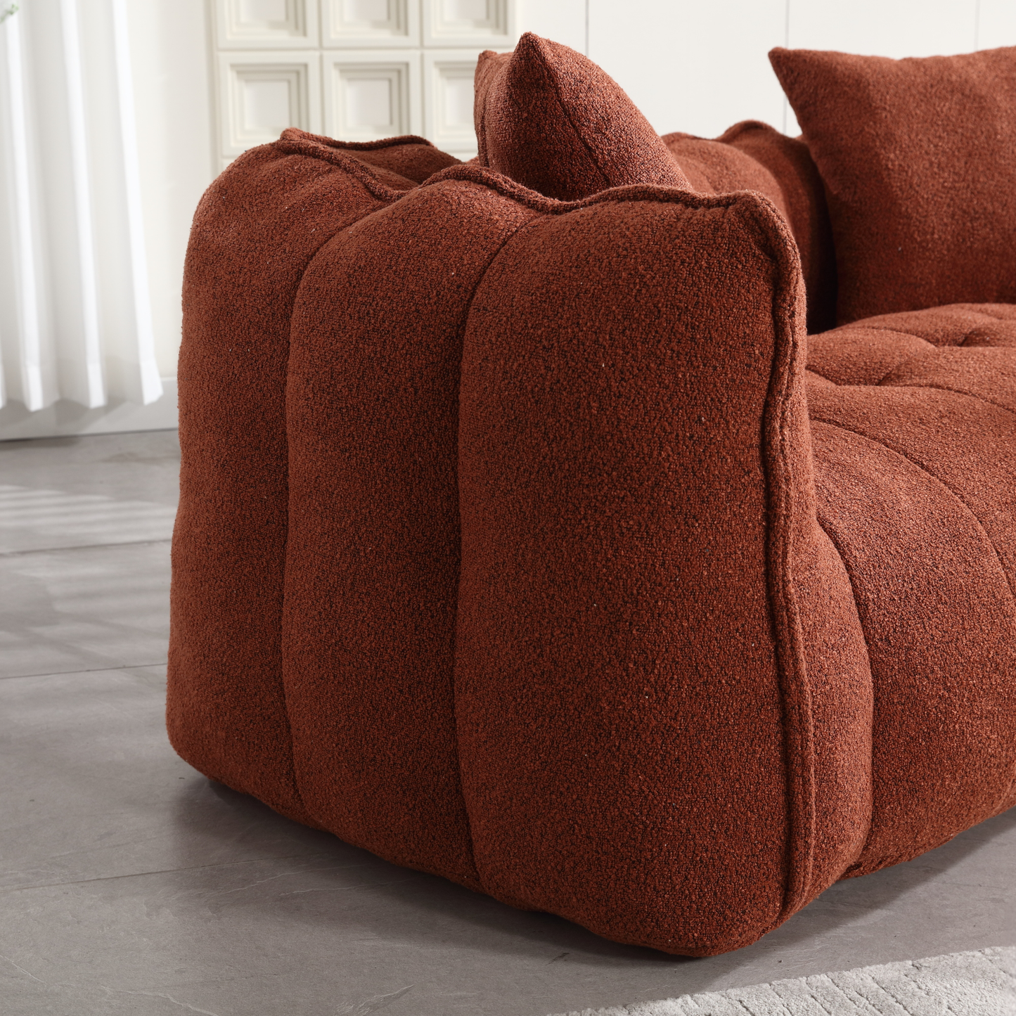 Plush terracotta boucl fabric sofa with tufted cushions and soft rounded armrest