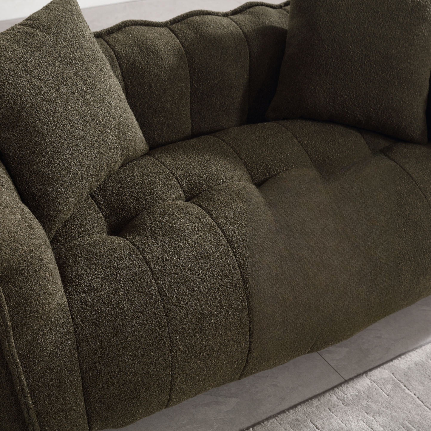 Deep green textured sofa with tufted seat and matching pillows