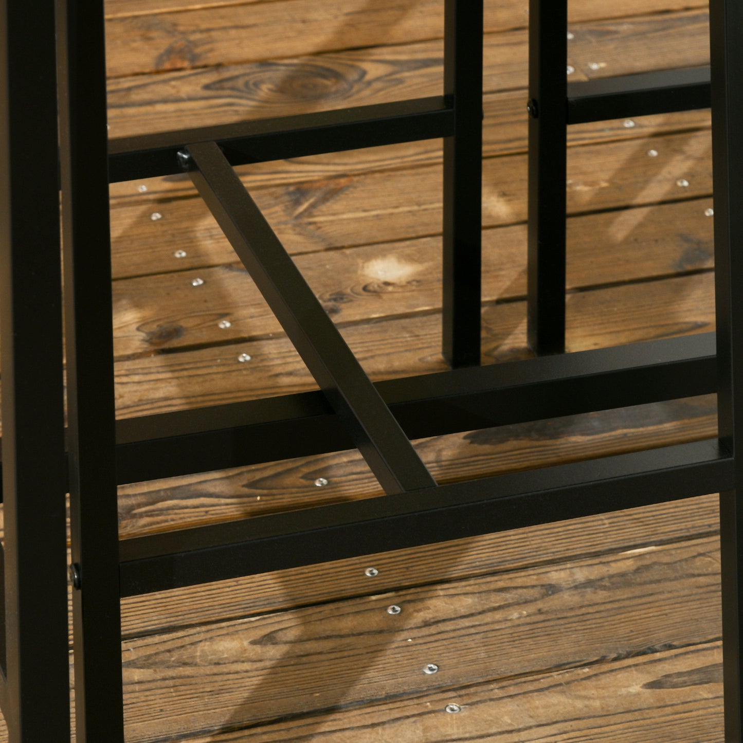 Black metal table legs with reinforced bracing on wooden deck