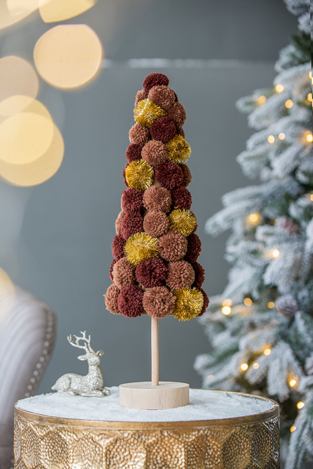 A rustic pom pom Christmas tree in burgundy brown and gold perfect for holiday decor