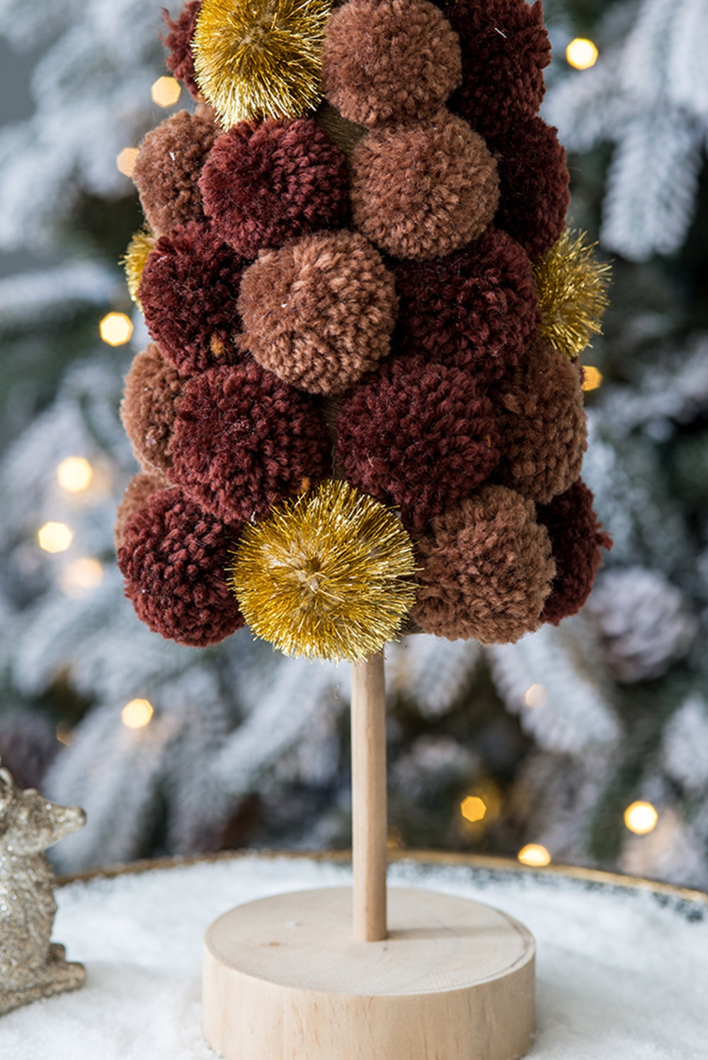 Textured pom pom Christmas tree in brown and gold with wooden base