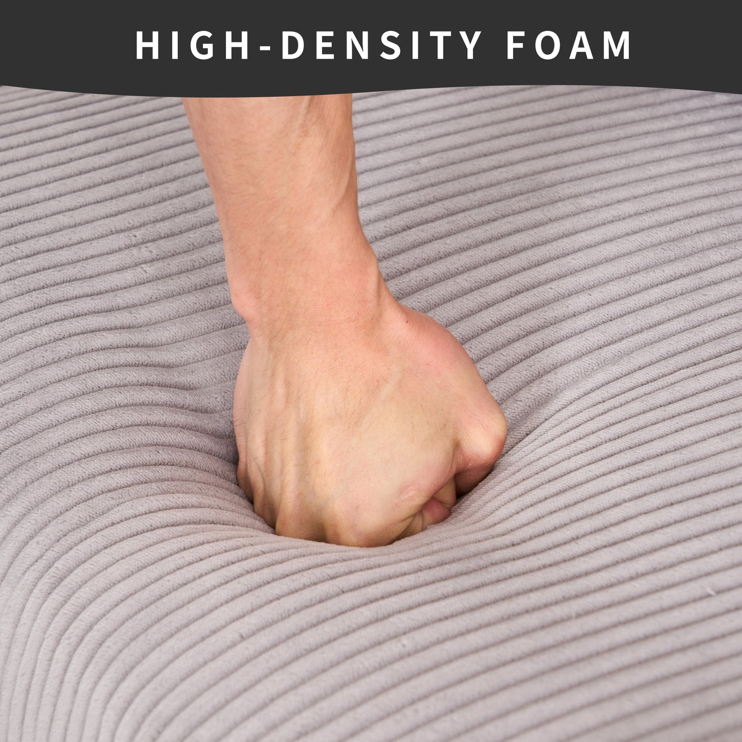 Hand pressing into gray highdensity foam demonstrating plushness