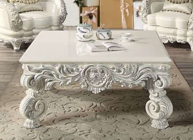 Ornate white carved coffee table with scrolled legs and decorative apron