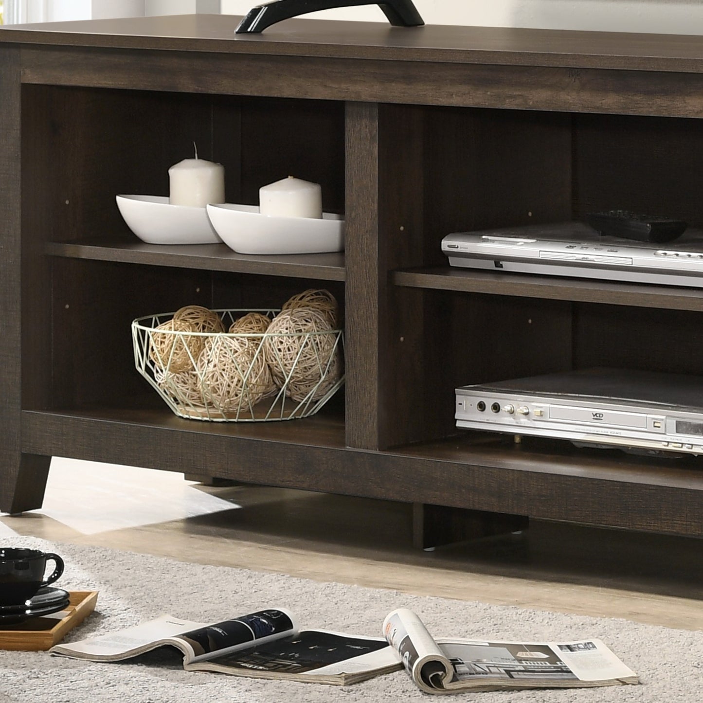 Dark wood media console with two DVD players and decorative white bowls on shelves