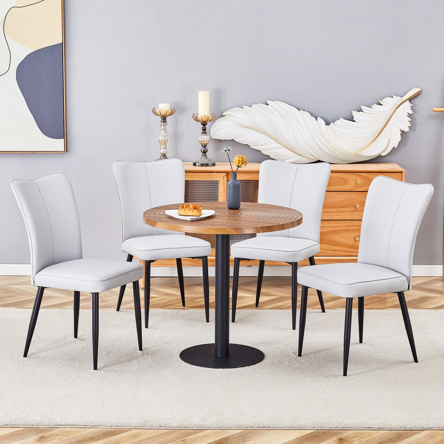 Light gray upholstered dining chairs with black legs surrounding a round wood table
