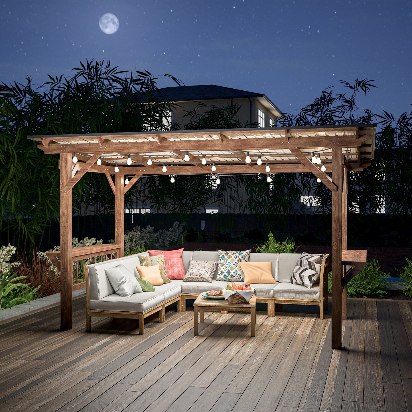 Modern sectional patio furniture with decorative pillows under a wooden pergola at night