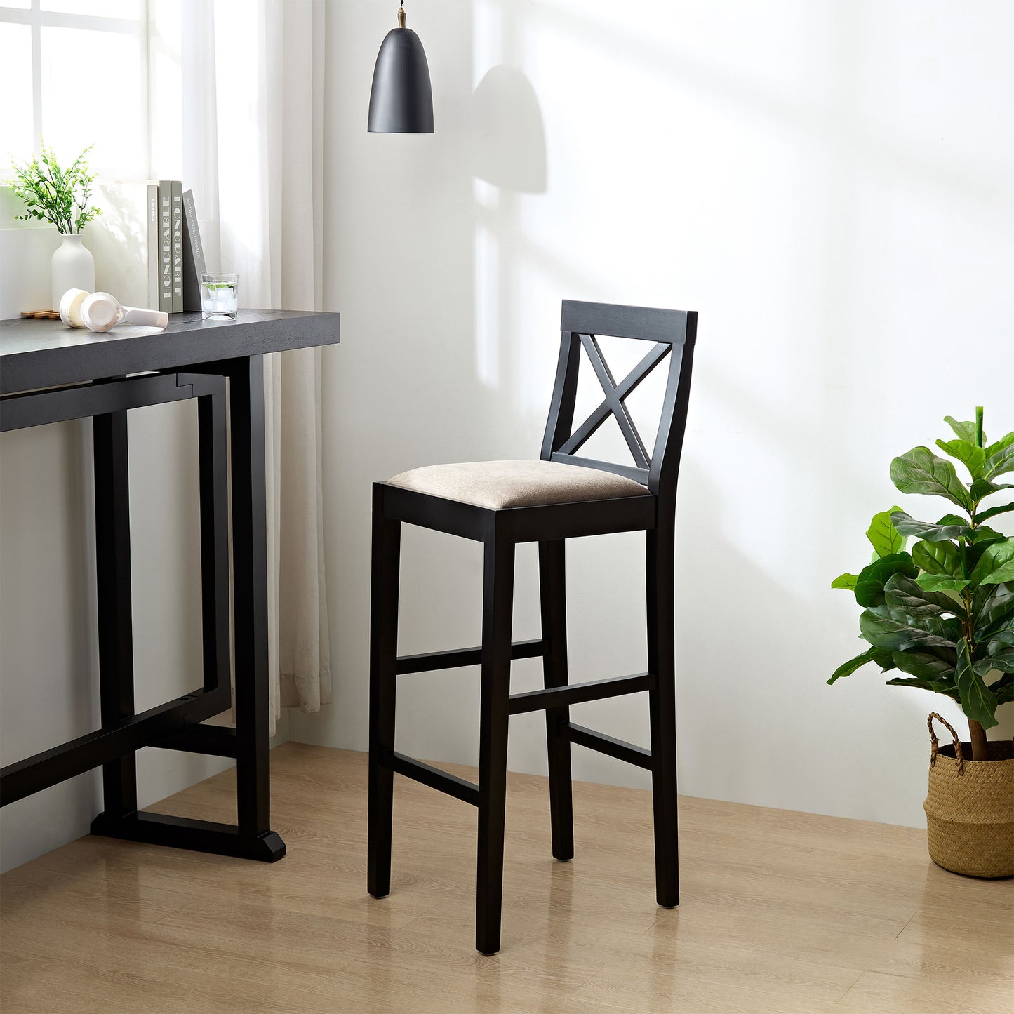 Black wooden bar stool with a beige upholstered seat and Xback detail