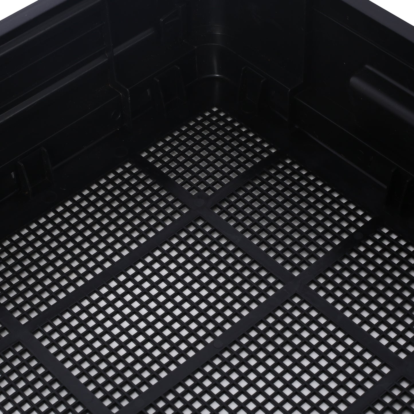 Black plastic hydroponic tray with a perforated grid bottom for drainage