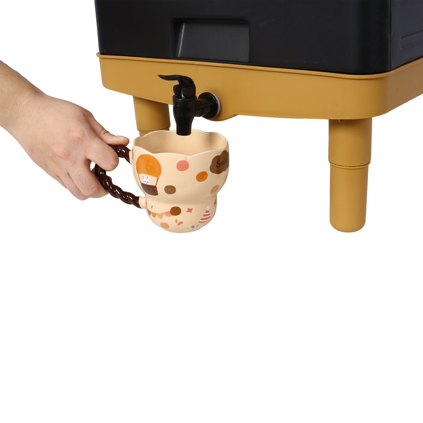 Hand holding a cute smiley face mug under a dispenser of a black and yellow composter
