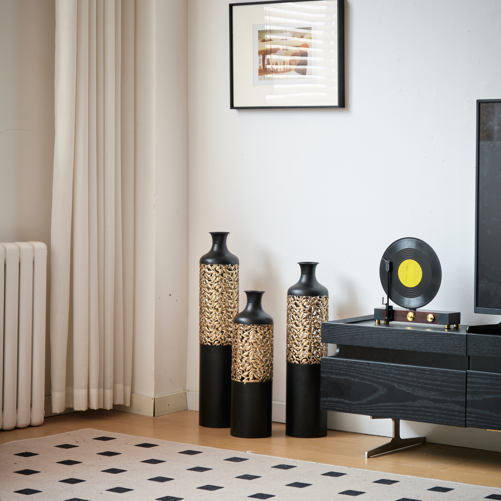 Tall black floor vase with intricate gold metal overlay pattern
