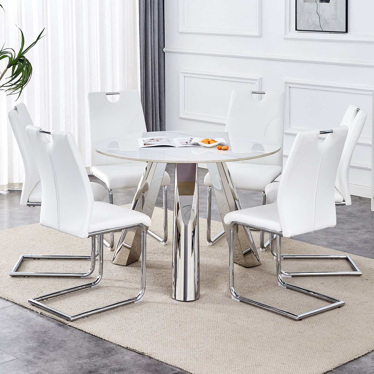 White leather dining chairs with chrome sled legs around a round glass table