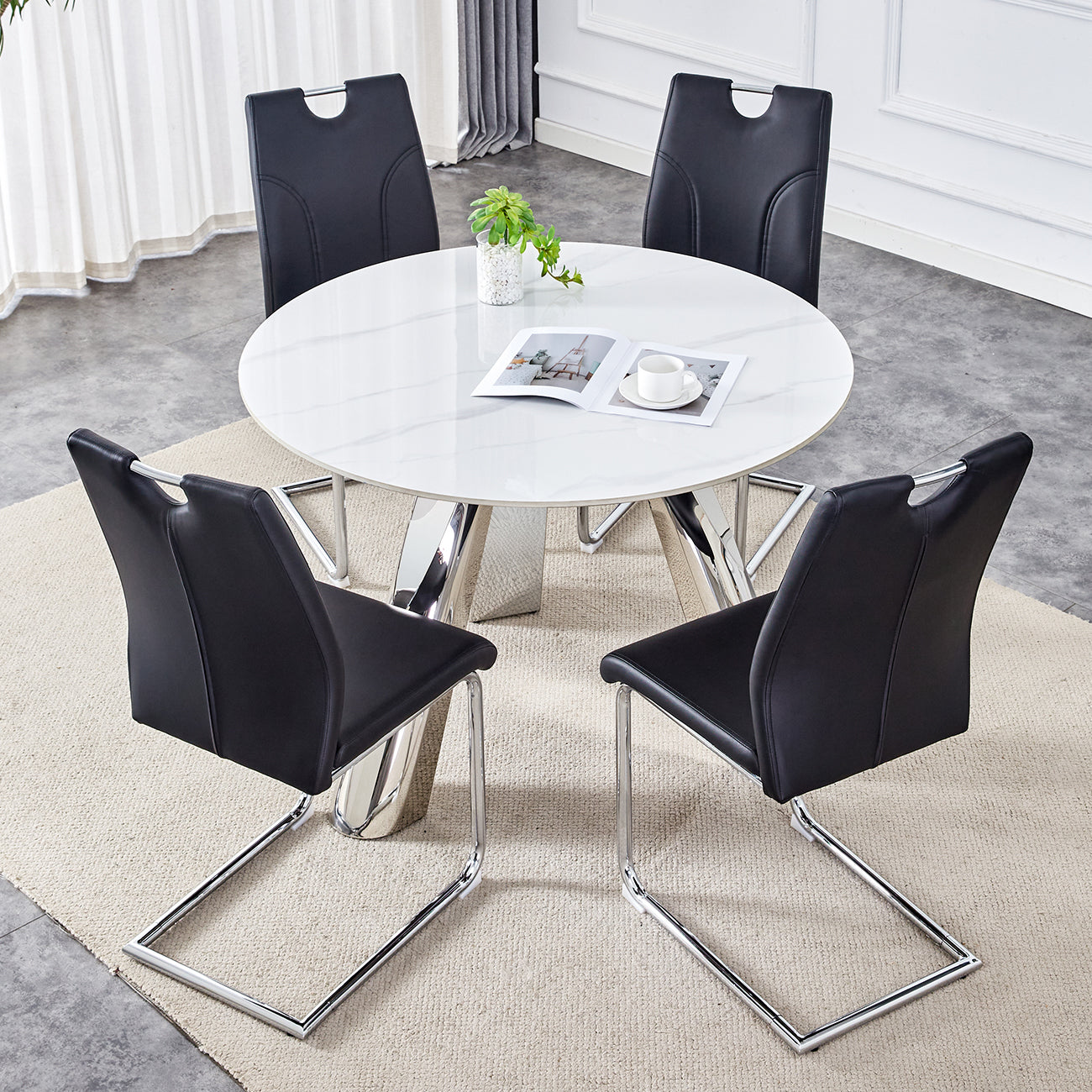 Black faux leather dining chairs with chrome legs surrounding a white marbletop table