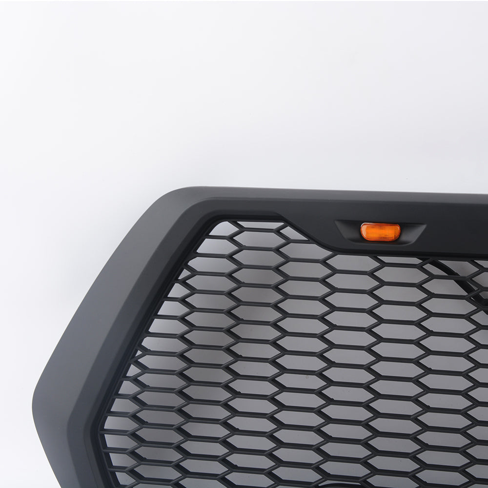 Matte black custom truck grille with hexagonal pattern and amber LED light