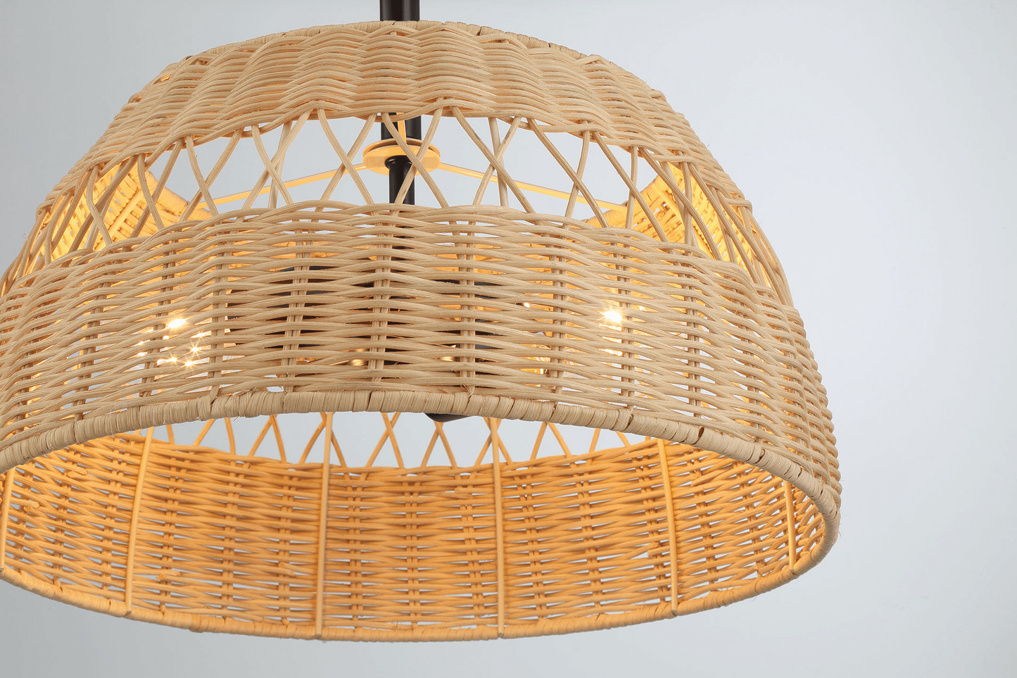 Natural rattan pendant light with a woven dome shade emitting a warm glow