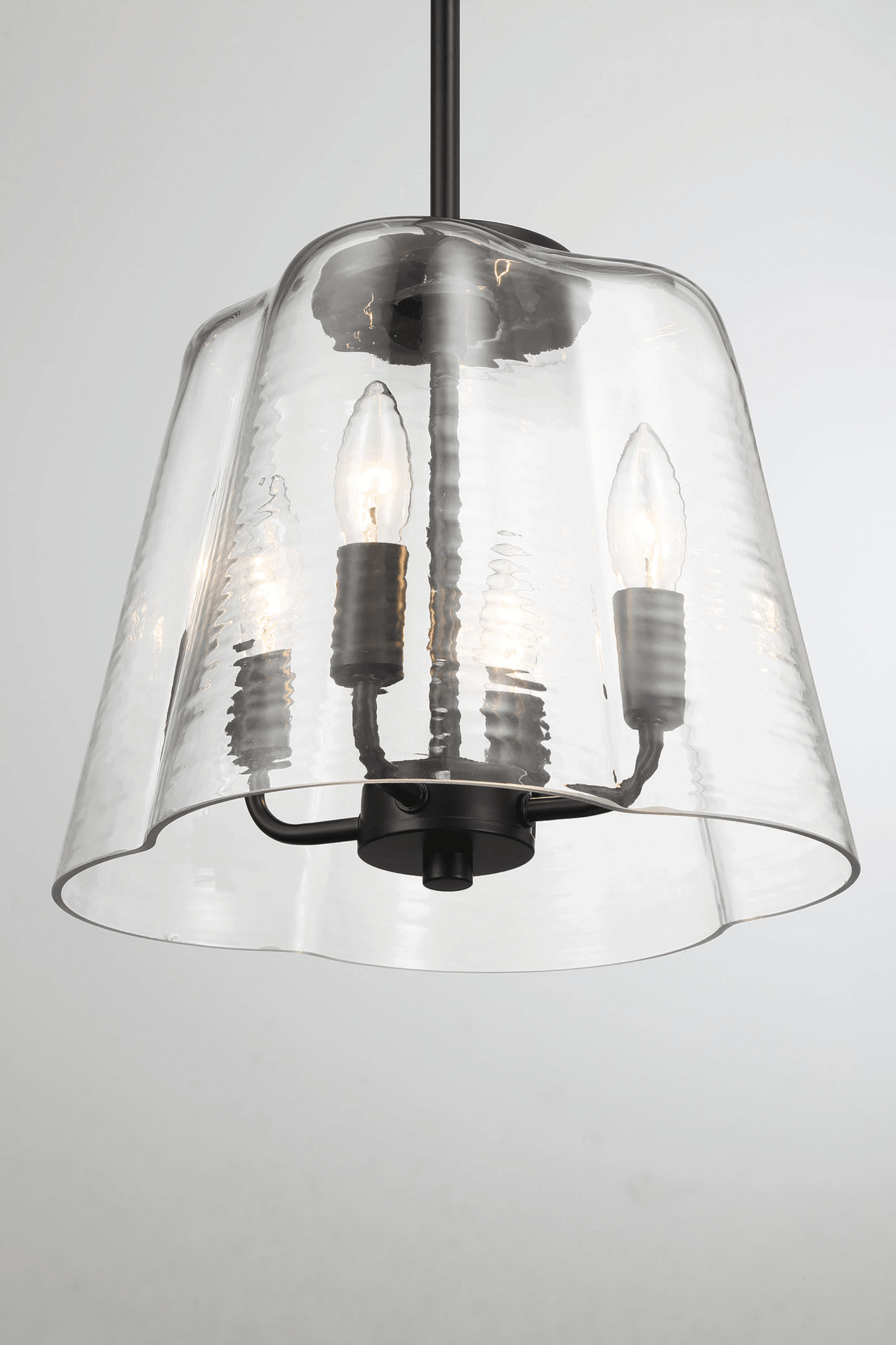 Textured glass bell pendant light with matte black finish warm bulb illumination