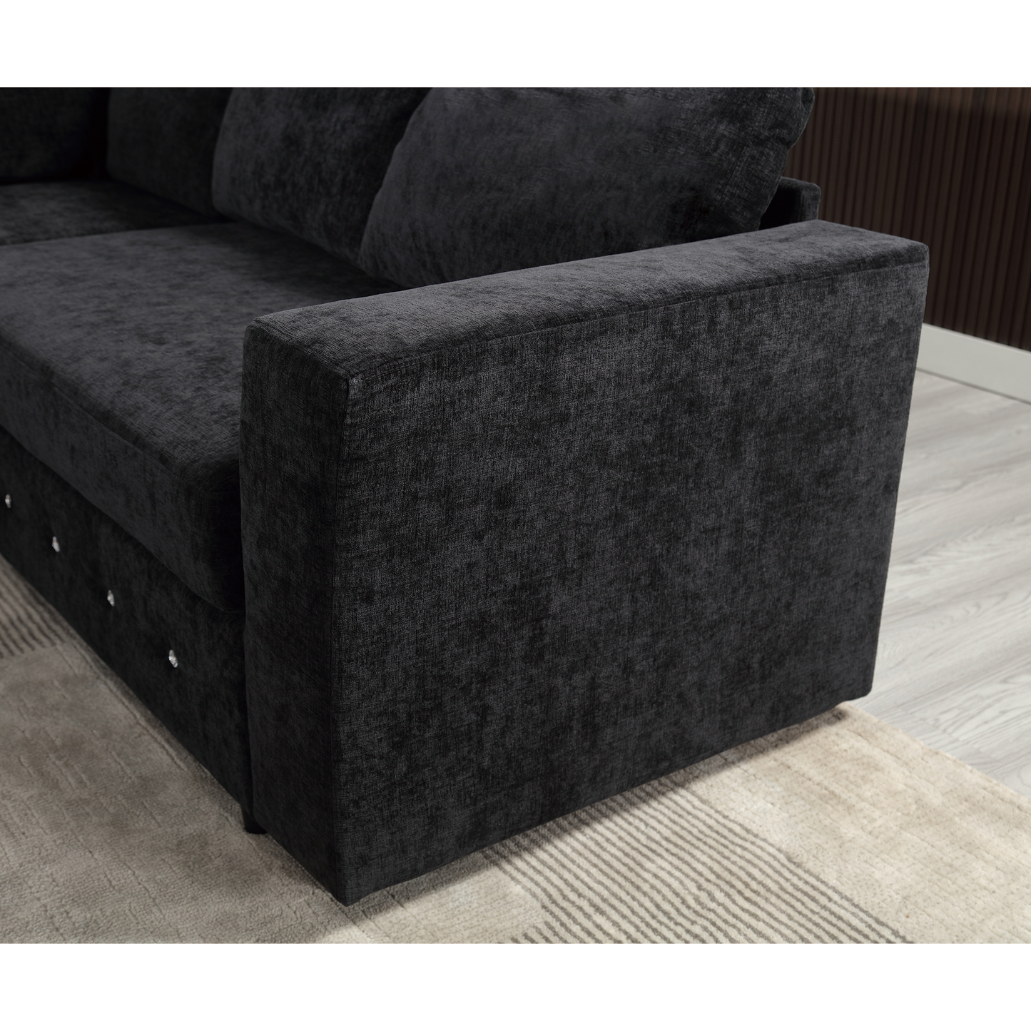 Closeup of a dark grey fabric sofa armrest with diamond tufting detail