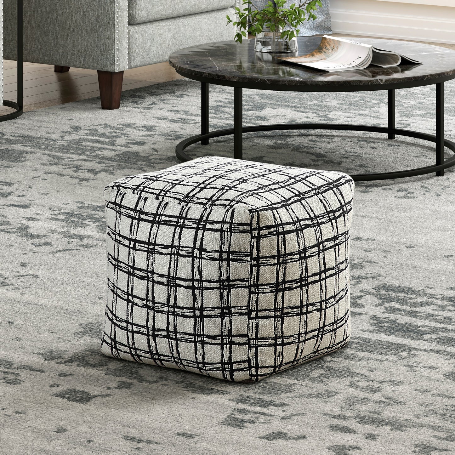 Black and white plaid ottoman with fabric upholstery perfect for living room seating